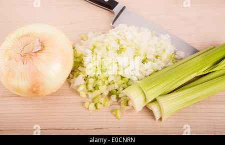 Hacken frische Zwiebeln und Sellerie auf ein Holz Schneidebrett Stockfoto