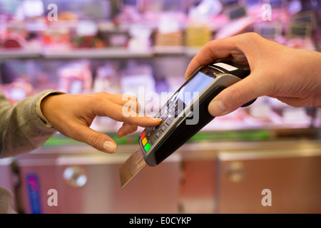 Weiblichen zahlenden Plastikkarte Shop Metzger Code Supermarkt Stockfoto