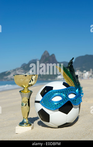 Brasilien Fussball Champion Trophy mit Fußball Karneval Maske auf Ipanema Strand Rio de Janeiro Brasilien Stockfoto