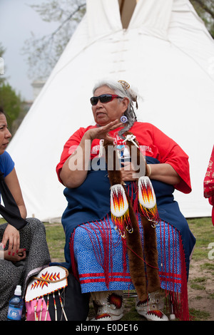 Indianer Seniorin sitzt vor einem tipi Stockfoto
