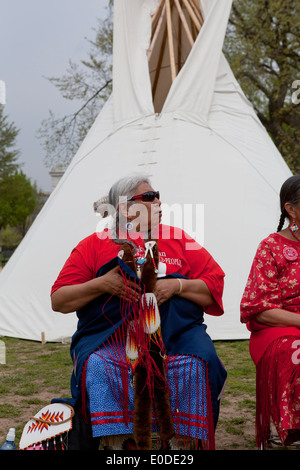 Indianer Seniorin sitzt vor einem tipi Stockfoto