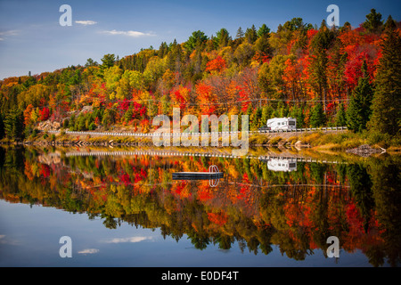 Herbst-Wald mit bunten Herbstlaub und Highway 60 spiegelt im See von zwei Flüssen. Algonquin Park, Ontario, Kanada. Stockfoto