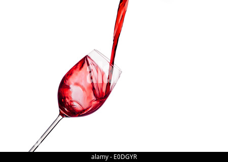 In einem Glas wird lebhaft roten Wein Eingeleert. Rotwein in den roten Weinglas, In Ein Glas Wird Schwungvoll Roter Wein eingeleert Stockfoto