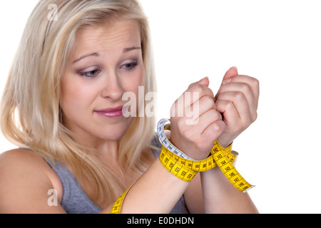 Eine junge Frau mit einem Dimension Band vor der nächsten Diät. Abnehmende und schnell, Eine Junge Frau Mit Einem Massband Vor der naechs Stockfoto