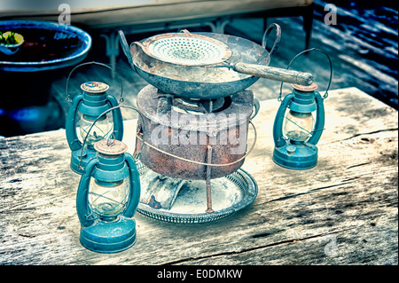 Petroleumlampe und Vintage Pan auf dem Holztisch Stockfoto