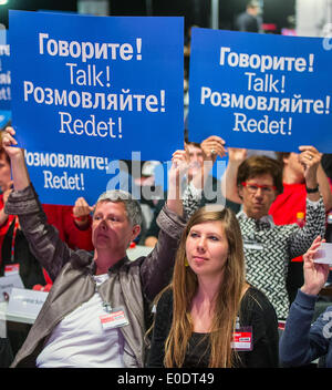 Berlin, Deutschland. 10. Mai 2014. Die Delegierten der Linkspartei halten Schilder mit der Aufschrift sprechen! in vier Sprachen, Russisch, Englisch, Ukrainisch und Deutsch bei dem Parteitag in Berlin, Deutschland, Mai 10. 2014. Die neue Parteiführung wird auf dem dreitägigen Kongress chosed sein. Foto: HANNIBAL/Dpa/Alamy Live News Stockfoto