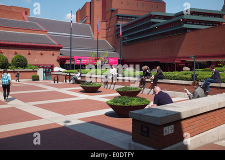 Menschen Chat und lesen in der British Library-Hof. Ein sonniger Tag im Frühling in London Großbritannien UK britische Euston Road Stockfoto