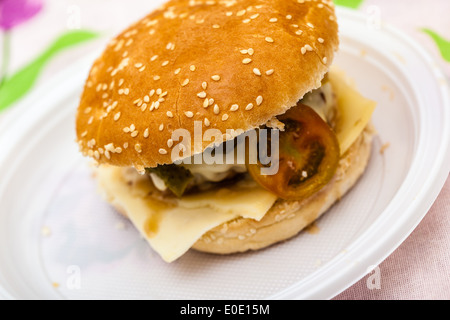 einen leckeren hausgemachten Hamburger mit Käse, Tomaten und Gurken Stockfoto