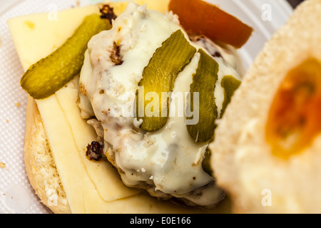 einen leckeren hausgemachten Hamburger mit Käse, Tomaten und Gurken Stockfoto