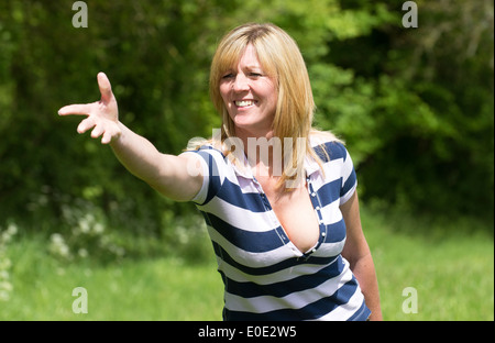 Frau mit offenen Hand und ausgestrecktem Arm fangen und werfen Stockfoto