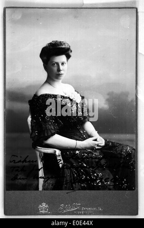 Ein Vintage-Porträt einer sitzenden Frau, aufgenommen auf einem Schwarzweißfoto. Das Bild bietet einen Einblick in die Vergangenheit und zeigt Mode und historische Porträts. Stockfoto