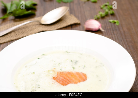 Platte-Wit-Kraut-Suppe und Räucherlachs auf einem Holztisch Stockfoto