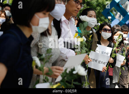 Seoul, Südkorea. 10. Mai 2014. Menschen halten Schilder und Blumen während ihrer "bleiben immer noch" stillen Marsch gegen das, was sie darauf bestehen, lax Reaktion des President Park Geun-hyes Regierung nach der Fähre eingesunken war Sewol aus der südwestlichen Insel Jindo am 16. April 2014, auf der Straße, Seoul, Südkorea, am Samstag, 10. Mai 2014 Gewässer. Zeichen zu lesen, "Stillhalten", Kapitän der Sewol pasquinading, wurde, die eine Nachricht für die Fahrgäste bis auf weiteres warten, wenn die Fähre, nach den örtlichen Medien sank Rundfunk. Stockfoto