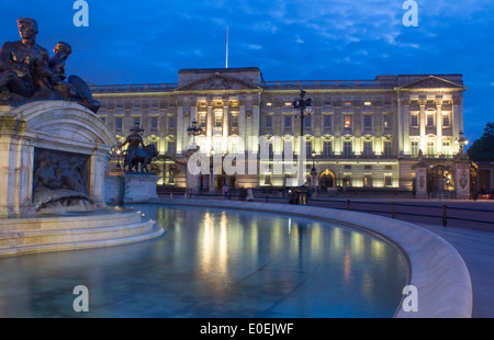 Buckingham-Palast in der Nacht mit Victoria Memorial Statuen spiegelt sich im Wasser des Brunnens London England UK Stockfoto