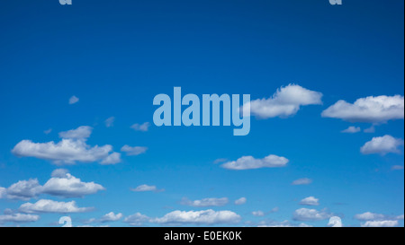 Der leuchtend blaue Himmel ist mit flauschigen weißen Wolken gefüllt, die eine ruhige und malerische Outdoor-Szene schaffen. Stockfoto
