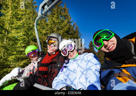 Lächelnden Freunde in Skimasken sitzen am Aufzug Stockfoto