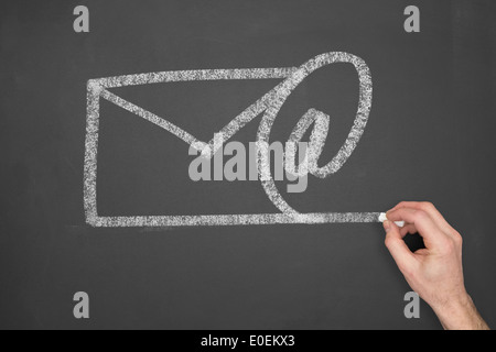 Ein Geschäftsmann, zeichnen eine e-Mail-Symbol auf einer Kreidetafel. Stockfoto