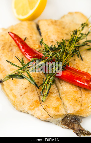 heiße Braten Filet Fisch auf Teller mit Chili und Zitrone Stockfoto