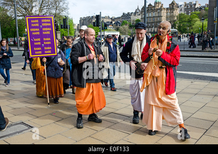 Mitglieder der Hare-Krishna-Bewegung singen wie sie ihren Weg entlang der Princes Street in Edinburgh, Schottland, Großbritannien. Stockfoto