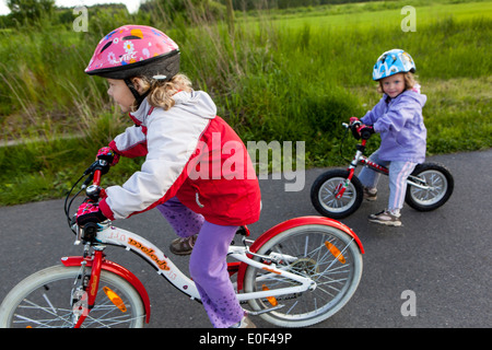 Zwei Kleinkinder mit Fahrradhelmen Kinder fahren Fahrräder Radfahren auf dem Radweg Kinder fahren Fahrrad Stockfoto