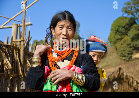 Eine Naga Frau mit ihrem tätowierten Gesicht, ein Baby zu tragen. Stockfoto