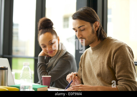 Junger Mann hart studieren mit Frau sitzen. Studenten für Abschlussprüfungen vorbereiten. Stockfoto