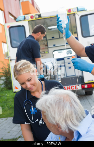 Paramedizinische Team helfen verletzt älteren Patienten auf Straße Stockfoto