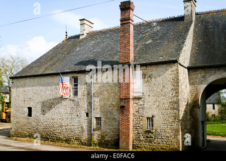 Amerikanische Flagge Hangng vom Fenster der alten Bauernhaus in Sainte-Marie-du-Mont, Normandie, Frankreich. Stockfoto