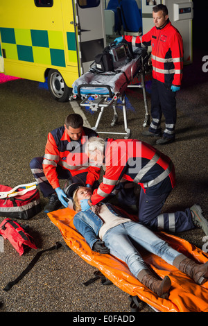 Notfall-Team helfen Verletzten Motorradfahrer Frau in der Nacht Stockfoto