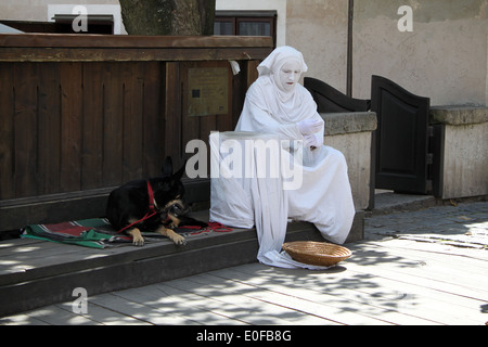 Lebende Statue Straßenkünstler und seinem Hund ruht fungiert zwischen. Stockfoto