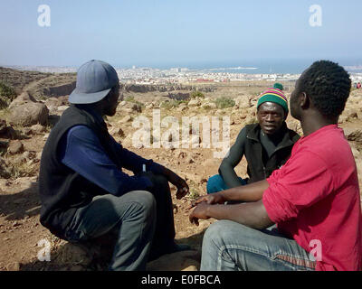 Eine Gruppe von jungen afrikanischen Einwanderern sitzt auf Monte Forcas vor die spanische Exklave Melilla in Marokko, 10. Mai 2014. Flüchtlinge zu sammeln im illegale Flüchtlingslager in der Nähe der Exklave Melilla befindet sich an der Nordküste von Afrika, die Grenzzäune nach Spanien zu überqueren. Foto: Meiko Haselhorst/Dpa - NO WIRE SERVICE Stockfoto