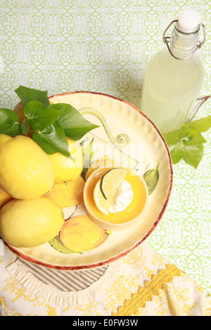 Zitronen, Zitronentorte und Limonade auf einem gelben Teller und Serviette. Stockfoto
