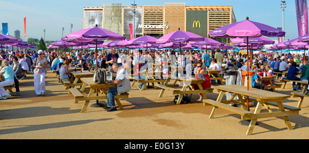 Bänken und Sonnenschirmen in der London 2012 Olympische Park mit McDonalds Zwischenlager jenseits Stockfoto