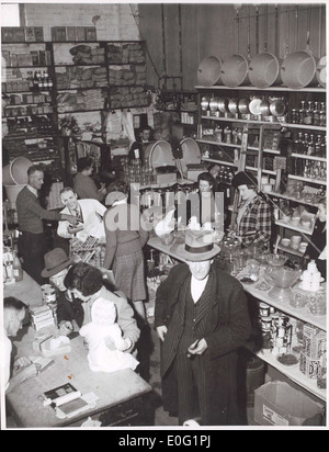 Diese Abbildung zeigt Kunden, die im Hardware-Bereich von Bell and Macaulay's Store in Drouin, Victoria, einkaufen. Die Szene bietet eine Momentaufnahme des täglichen Lebens in einer kleinen australischen Stadt Mitte des 20. Jahrhunderts, wobei der Schwerpunkt auf Handel, Einkaufskultur und der Umgebung der Zeit liegt. Stockfoto