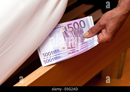 Eine Menge von Euro Banknoten sind versteckt unter dem Bett., Viele Euro-Geldscheine Werden Unter Dem Bett Versteckt. Stockfoto