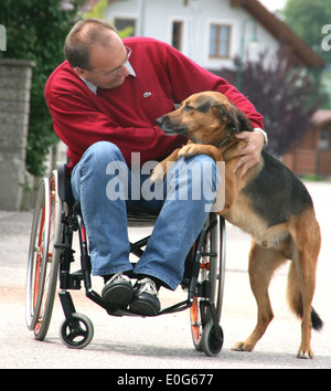 Mann im Rollstuhl mit Hund - eine in einem Rollstuhl mit Hund [], Schranke, Schranken, behindern, geeignet für Behinderte, s Stockfoto