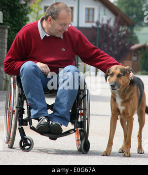 Mann im Rollstuhl mit Hund - eine in einem Rollstuhl mit Hund [], Schranke, Schranken, behindern, geeignet für Behinderte, s Stockfoto