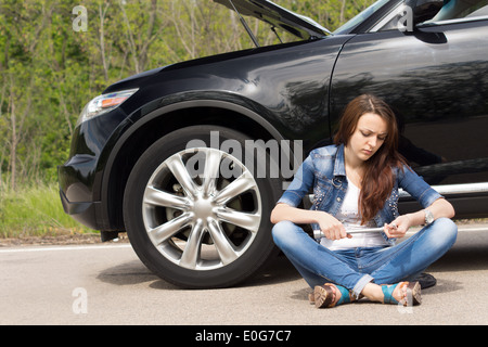 Frau wartet neben ihr Auto zerlegt Stockfoto