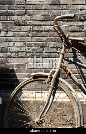 Altes Fahrrad gelehnt Mauer in einem chinesischen hutong Stockfoto
