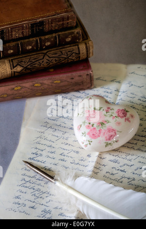 eine Feder auf einen alten Brief mit Büchern Stockfoto