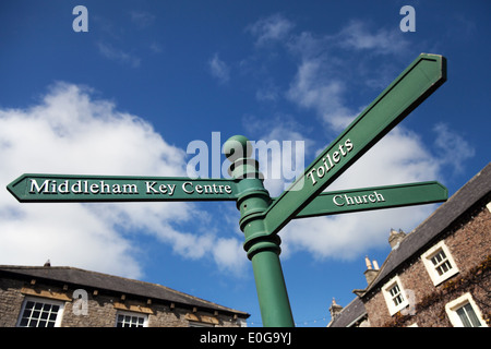 Straßenschilder zu verschiedenen Zielen. Middleham Dorf Zeichen, North Yorkshire Dales, Großbritannien Stockfoto