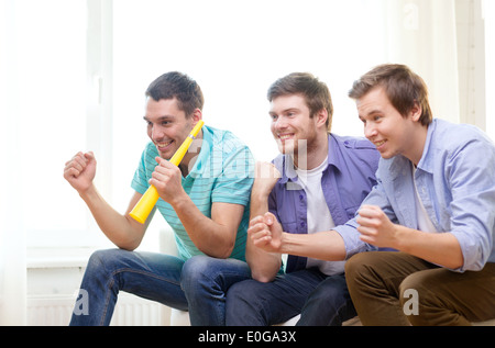 glücklich männlichen Freunde mit Vuvuzela Sport ansehen Stockfoto
