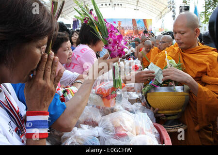 Bangkok, Thailand. 13. Mai 2014. Thai Anti-Regierungs-Demonstranten anzubieten Essen buddhistische Mönche, wie sie die Visakha Bucha-Tag während einer Kundgebung vor dem Büro der Vereinten Nationen in der Nähe der Regierungsgebäude in Bangkok, Thailand, 13. Mai 2014 markieren. Thai Anti-Regierungs-Demonstranten begann ihre Rallye-Website vom Lumpini Park in der Nähe der Regierungsgebäude am Montag zu verschieben. Bildnachweis: Rachen Sageamsak/Xinhua/Alamy Live-Nachrichten Stockfoto