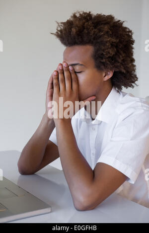 Lässige Geschäftsmann erschöpft an seinem Schreibtisch Stockfoto