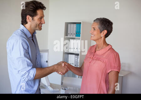 Lässig lächelnd Geschäftsleute Händeschütteln Stockfoto