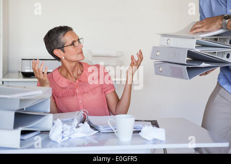 Lässige Businesswomans Arbeitsbelastung immer größer und größer Stockfoto