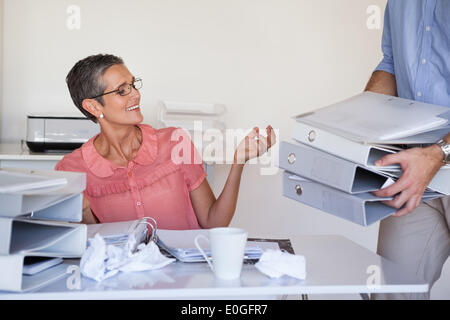 Lässige Businesswomans Arbeitsbelastung immer größer und größer Stockfoto