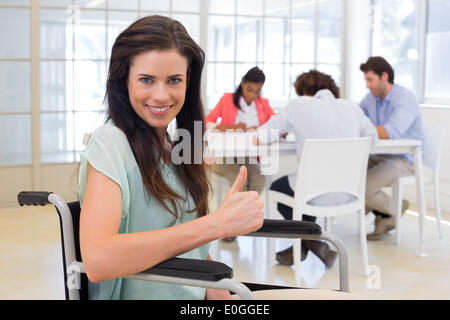 Geschäftsfrau mit Behinderung gibt Daumen hoch für Kamera Stockfoto