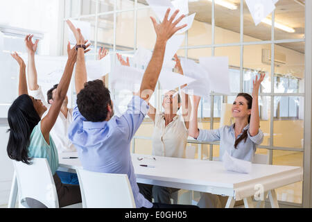 Fröhliche Mitarbeiter werfen Papier und lächelnd Stockfoto