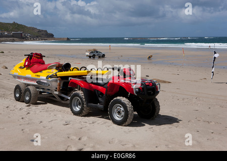 Quad-Bike und Jet-Ski PWC ein RNLI Rettungsschwimmer retten Handwerk und eine Abholung am Strand von Sennen Cornwall. Stockfoto